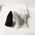 Dual-sided black makeup sponge blender in frosted storage pouch with minimalist background - Frosted Bag / Conical Cut Style / Black