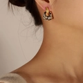 Pendientes geométricos bañados en oro de 18k con estampado de leopardo en una modelo - Pendientes geométricos / Pendientes de esmalte azul-negro