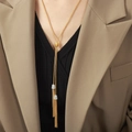 Elegante lange gouden kwastjesketting met zirkonia accenten op een kaki blazer outfit - Goud