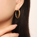 Detailed close-up of gold-plated twisted rope hoop earring on model showing metal texture - Twisted Rope Style (F1417) / Gold