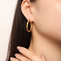 Close-up of stylish gold-plated twisted hoop earrings on a model for daily wear - Twisted Rope Style (F1423) / Gold