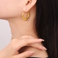 Orecchini a cerchio a U placcati in oro lucido indossati da una modella donna - Stile F1196 / Oro