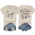 Dettaglio fronte e retro della t-shirt beige con grafica Gigi e shorts in denim strappati - S / Sabbia (Grafica Nera)