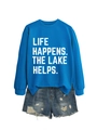 Close-up of blue 'LIFE HAPPENS THE LAKE HELPS' sweatshirt and distressed denim shorts - Klein Blue (White Font)