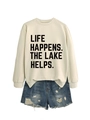 Detail of white crewneck sweatshirt with 'LIFE HAPPENS' text and distressed denim shorts - Sand (Black Font)