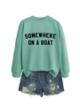 Detailed view of mint green sweatshirt with SOMEWHERE ON A BOAT text and denim shorts - Light Green (Black Font)