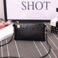 Chic black crocodile-textured small crossbody bag with gold zipper and stylish metal charm - Black