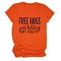 Detailed flat lay of orange cotton T-shirt with black FREE HUGS slogan on the front - Orange (Black Font)