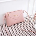 Light pink envelope crossbody bag with gold Chleo logo and leaf pendant detail - Pink
