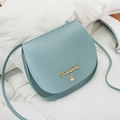 Minimalistische hellblaue Satteltasche mit goldenem Logo auf weißem Leinenstoff - Blau