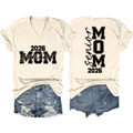 Dettaglio della maglietta beige con scollo a V, stampa 2026 MOM Senior e shorts di jeans - S / Sabbia (Carattere Nero)