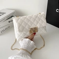 Elegant white quilted crossbody bag with gold turn-lock and chain strap on marble - White