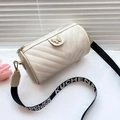 Quilted V-pattern cylinder bag in cream white with butterfly clasp and wide logo strap - White