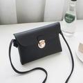 Minimalist black leather crossbody square bag with golden buckle in cafe setting - Horizontal / Black