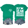 Flat lay of green short sleeve T-shirt with My Heart Is On That Stage back print and denim shorts - Dark Green (White Font)