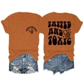 Detail eines orangen Baumwoll-T-Shirts mit Gothic-Text und Skeletthand-Grafikdruck - Gebranntes Orange (Schwarz Grafik)