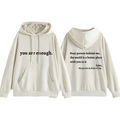 Détail du sweat à capuche crème avec citations positives sur le devant et le dos - Sable