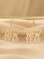 Dettaglio orecchini Happy New Year in oro con perle su sfondo di raso - Stile Perla Dorata
