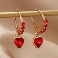 Boucles d'oreilles créoles cœur doré avec cristaux rouges sur fond de soie champagne - Rouge