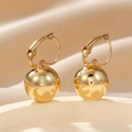 Makroaufnahme von goldenen Kugelohrringen mit Klappbügel auf cremefarbenem Satin - Gold