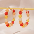 Colorful beaded C-shaped hoop earrings featuring frosted warm-toned beads on gold wire - Colorful