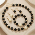 Elegant black beaded jewelry set with gold accents featuring necklace, bracelet and earrings - Black