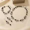 Vintage silver spider jewelry set with necklace bracelet and earrings on beige silk - Black