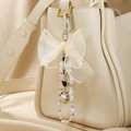Lace bow keychain with pearl strands and heart charms on a cream leather bag - Black Heart Bow Keychain
