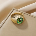 Macro detail of golden eye ring featuring a realistic green eyeball on luxury jewelry box - Gold Green Round Pupil