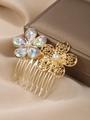 Vue détaillée de deux peignes à cheveux dorés avec des strass irisés et des perles - Fleur Goutte d'Eau