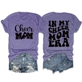 Flat lay of purple Cheer Mom Era t-shirt featuring vintage print and denim shorts - Purple (Black Font)