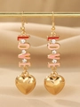 Détail de boucles d'oreilles LOVE dorées avec cœurs en émail rose et rouge sur support - Style Lettre Love Coeur