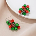 Détail de boucles d'oreilles de Noël avec cloches rouges et vertes sur céramique blanche - Style de Grappe de Clochettes en Métal Rouge et Vert (6)