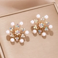 Macro shot of snowflake stud earrings with white pearls and iridescent crystals - Gold Pearl Rhinestone Snowflake Style (4)