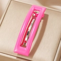 Pinza para el pelo rosa vibrante de acetato sobre elegante joyero beige - Rosa