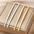 Moderne U-förmige Haarnadeln aus Metall in Gold und Silber matt auf einer Schmuckbox - Minimalistische Haargabel