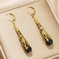 Detail view of vintage long drop earrings with gold filigree and black teardrop beads - Black