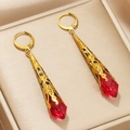Macro detail of red faceted teardrop earrings with vintage hollowed gold floral caps - Red