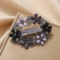 Vintage oval floral spring hair clip with purple rhinestones on a gold textured box - Gray