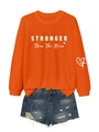 Detail of STRONGER text on orange crewneck sweatshirt with distressed denim shorts - Orange