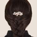 Detail of a golden alloy hair comb with crystals and pink pearls in dark hair - Small Pearl Hair Comb