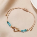 Detail eines Evil Eye Herz-Anhängers an verstellbarem beigem Webarmband für den Alltag - Herz (Hohlherz Böser Blick)