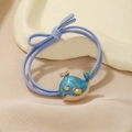 Close-up of blue whale enamel charm on elastic hair tie with light blue bow detail - Whale