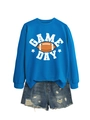 Close-up of Game Day football print on royal blue sweatshirt with ripped denim shorts - Lake Blue (White Graphic)