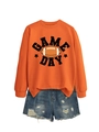 Flat lay of an orange Game Day sweatshirt paired with distressed blue denim shorts - Orange (Black Print)
