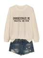 Flat lay of beige sweatshirt with 'Underestimate Me' slogan and ripped denim shorts - Sand