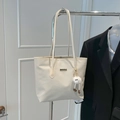 Borsa tote intrecciata bianco sporco con ciondolo in peluche appesa a una gruccia - Con Ciondolo / Bianco