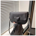 Detalle de cerca de bolso bandolera de cuero negro con grabado lichi y adorno de corazón - Negro