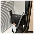 Detalle de bolso negro de hombro con textura de mármol y correa delgada - Negro