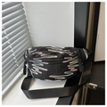 Detalle del bolso negro con bordado de arcoíris y textura acolchada de moda actual - Negro